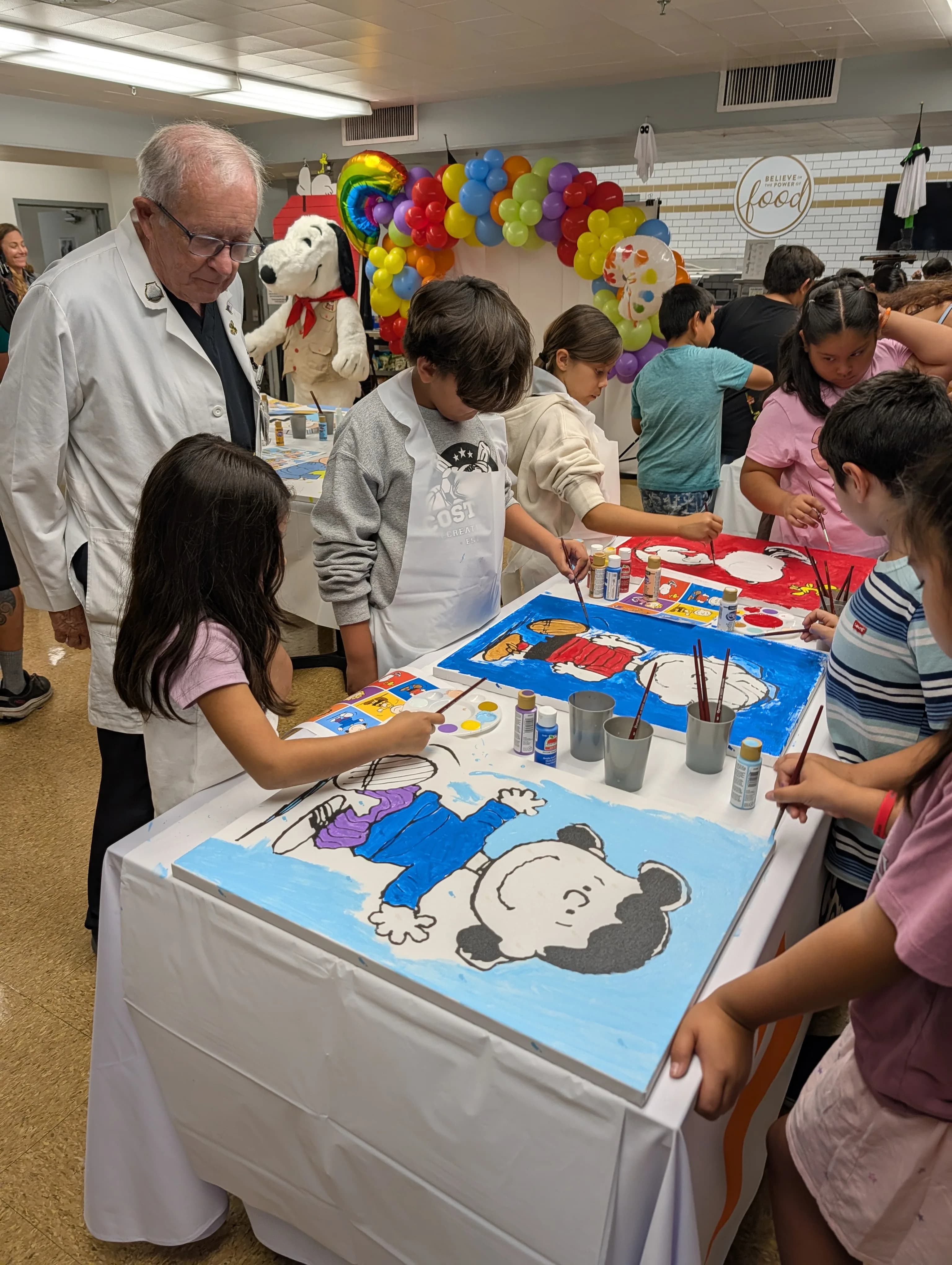 Dr. Fagan Snoopy and children from Eastman Elementary painting mural at Los Angeles Community Hospital
