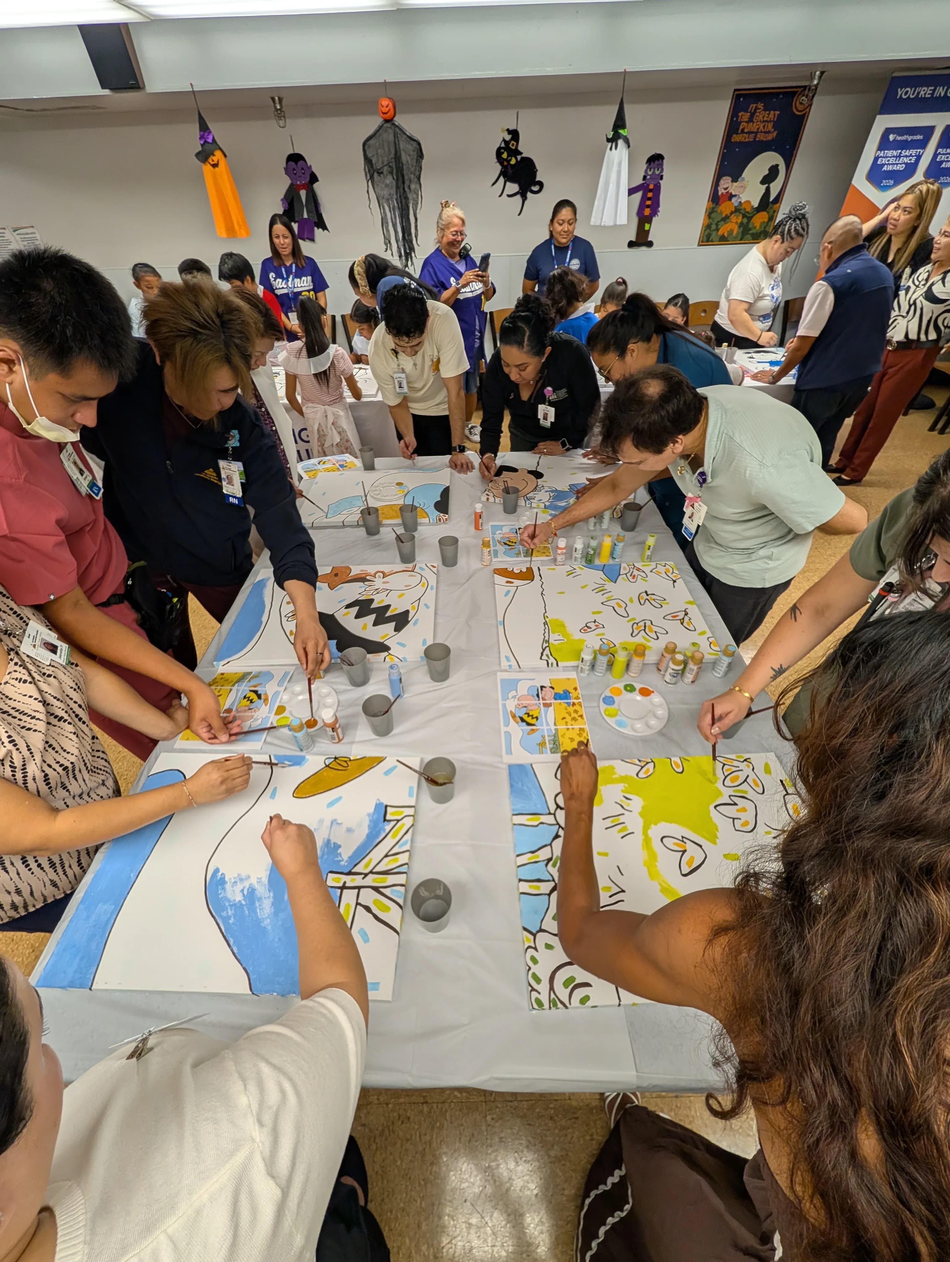 LACH staff and children from Eastman Elementary painting Peanuts mural