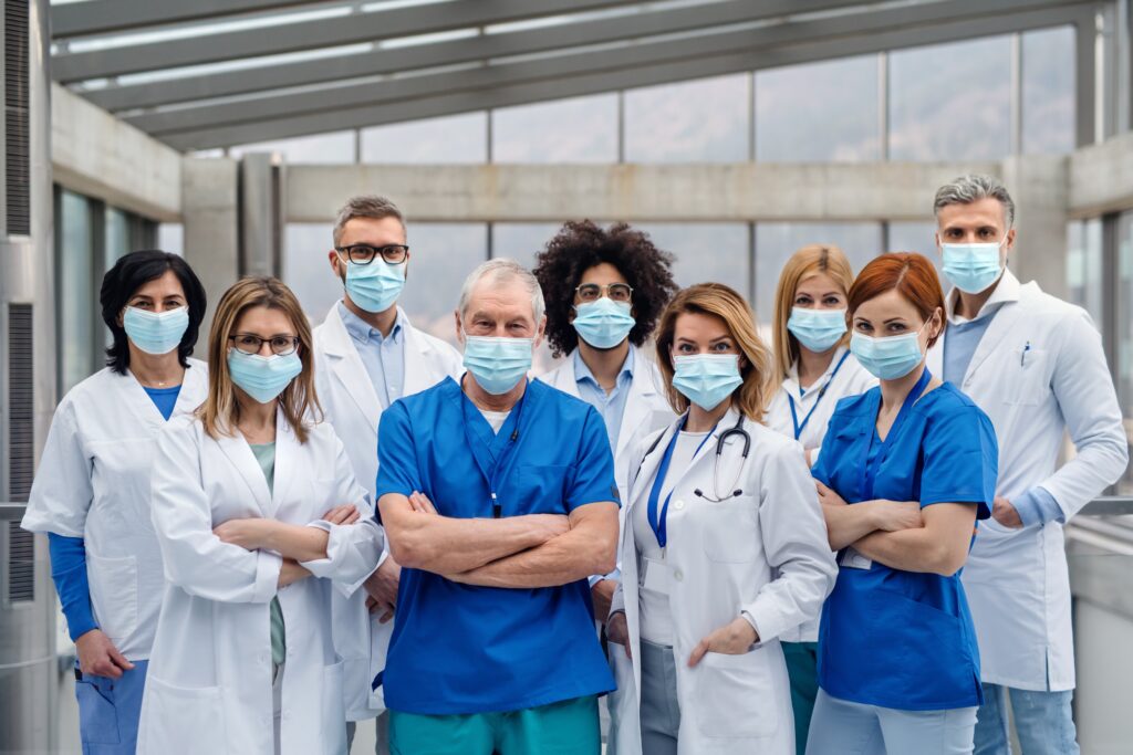 group of doctors with face masks looking at camera, corona virus concept.